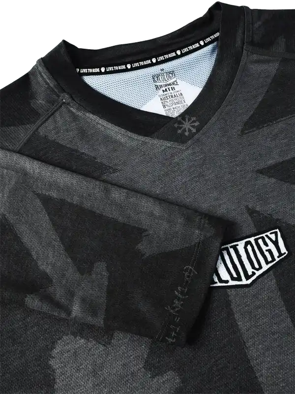 Men's black camo cycling jersey with 'Cycology' patch and performance fabric details