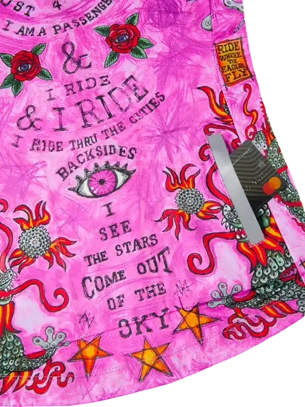 Pink cycling jersey with bold floral and star designs, featuring adventurous text and vibrant patterns.
