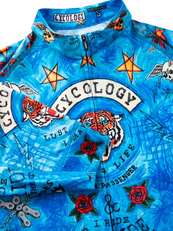 Blue cycling jersey with colorful graphic design with dragons, stars, and text and Cycology brand
