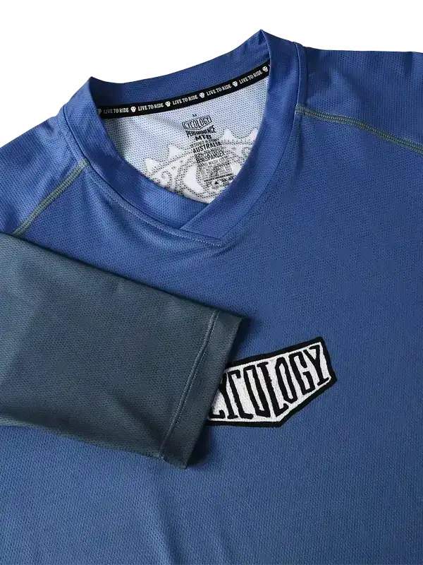 Blue men's cycling jersey with 'Cycology' patch and 'Live to Ride' collar tag, performance fabric