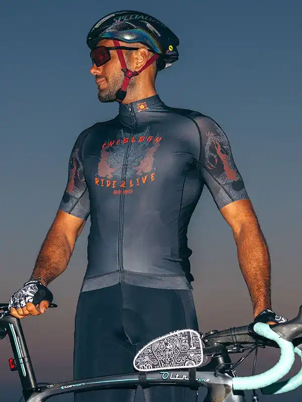 Man in men's cycling jersey with 'Ride & Live' graphic, helmet, and bike at dusk