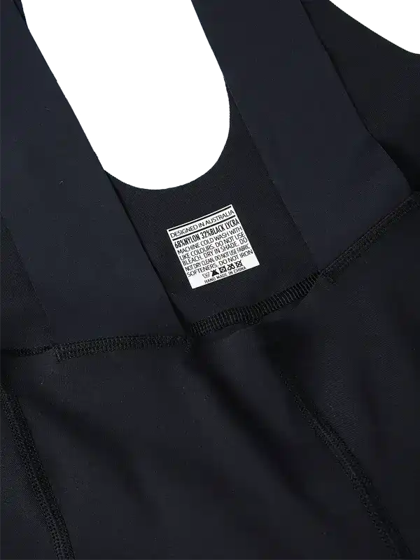 Black cycling bib shorts with care label, designed in Australia, featuring high-quality fabric and seamless stitching