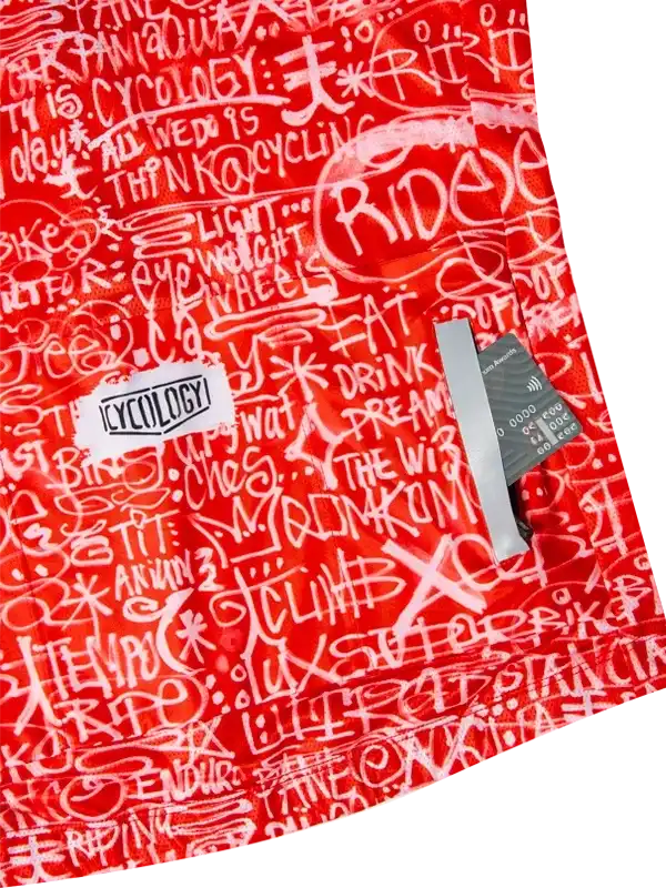 Red cycling jersey with white graffiti-style text, featuring 'RIDE' and 'CYCOLOGY' branding, ideal for men's and women's bike wear.