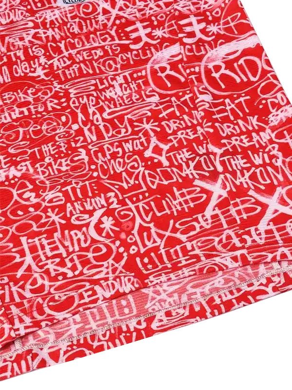 Red cycling jersey with white graffiti-style text, featuring phrases like 'RIDE' and 'EAT SLEEP CYCLE' for men's and women's bike wear.
