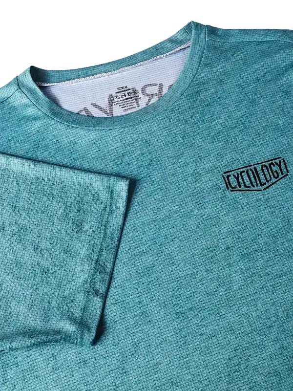 Teal men's cycling jersey with textured fabric and small logo, ideal for performance rides