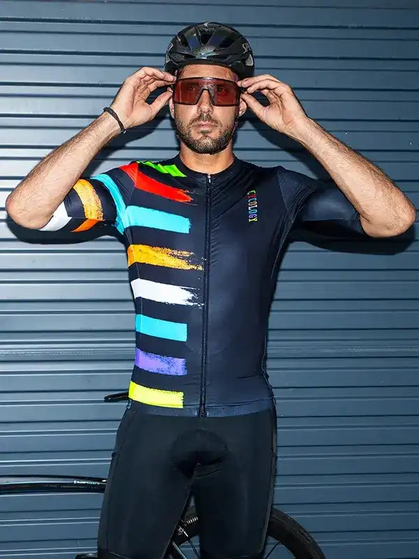 Man in colorful striped cycling jersey and helmet, adjusting sunglasses, ready for ride