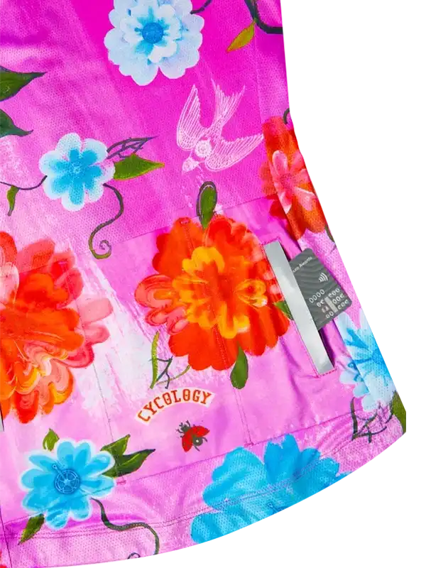 Vibrant floral cycling jersey with pink base, blue and orange blooms, and bird design for women's cycling wear.