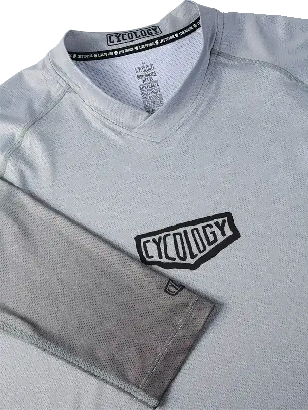 Gray cycling jersey with bold 'CYCOLOGY' logo, breathable fabric, ideal for men's and women's rides
