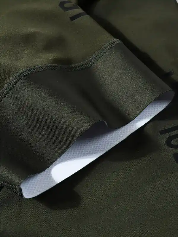 Close-up of an olive green cuff detail, showing a white inner grip lining and dark printed lettering on the fabric.