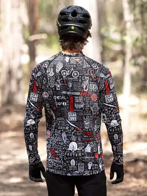 Men's cycling jersey with bold graphic print, worn on forest trail, featuring long sleeves and helmet