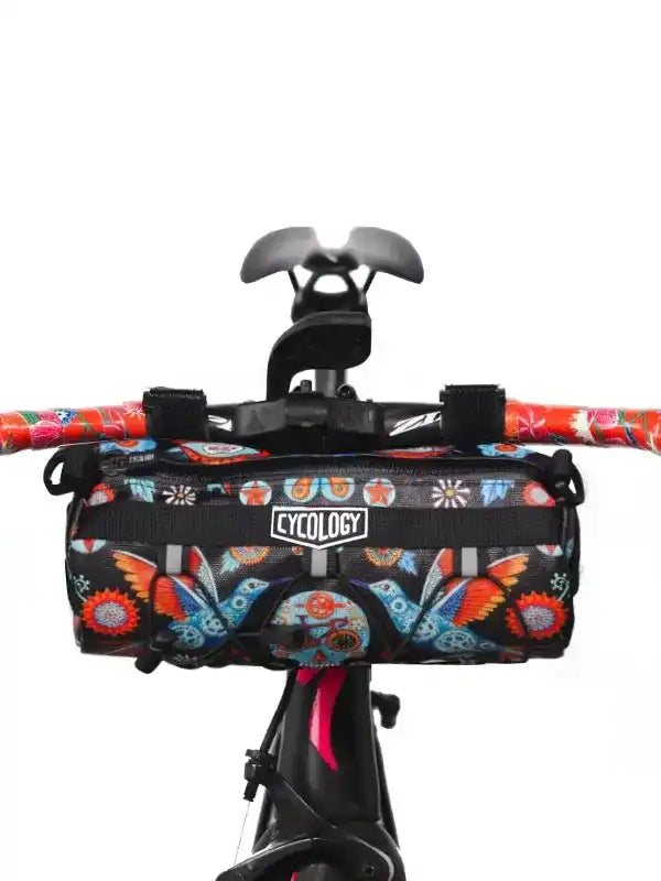 Cycology bike handlebar bag with colorful floral and butterfly print, mounted on bicycle handlebars