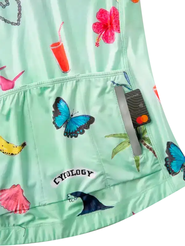Mint green cycling jersey with tropical print: butterflies, hibiscus, palm trees, and beach vibes for women's bike wear