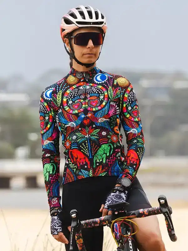 Woman in vibrant, patterned cycling jersey and helmet, ready for a ride on her road bike.