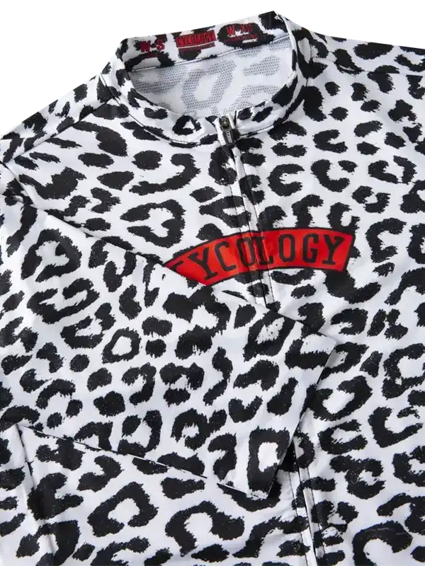 Women's cycling jersey with bold leopard print and red Cycology logo, featuring zip neck and performance fabric.