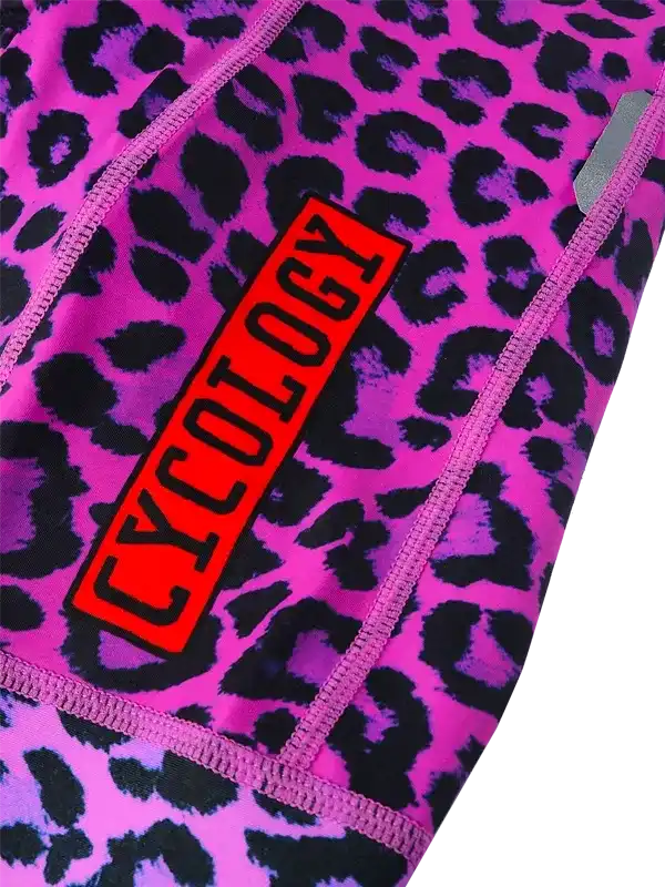 Pink leopard print cycling shorts with bold red Cycology logo, high-quality athletic wear for women