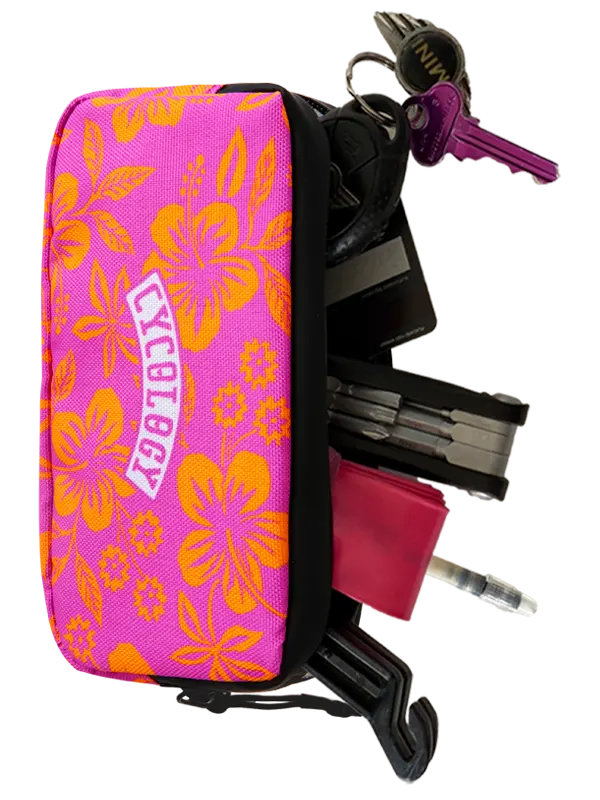 A pink and orange floral zippered pouch with the word 'CYBOLGY' printed on it, shown holding keys, a wallet, tools, and a pen against a white background.