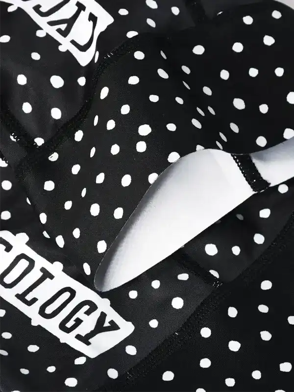 Black and white polka dot cycling shorts with bold logo detail, designed for comfort and style on the road.
