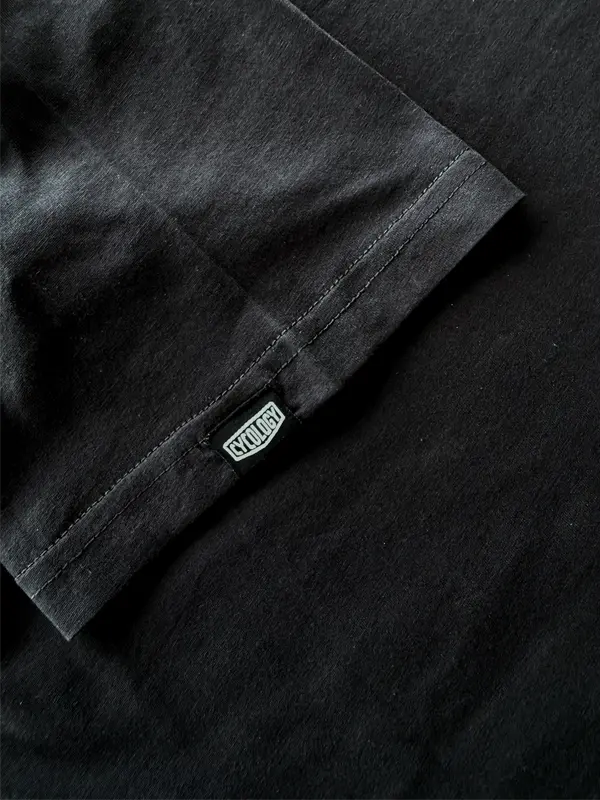 Close-up of a black shirt with a brand label on sleeve