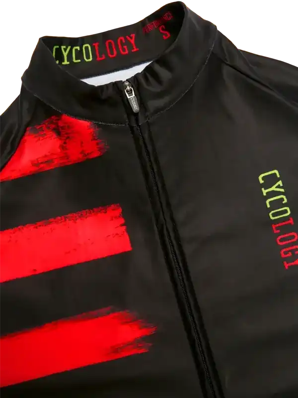 Black cycling jersey with red brushstroke design and green Cycology logo, featuring full zip and high collar.