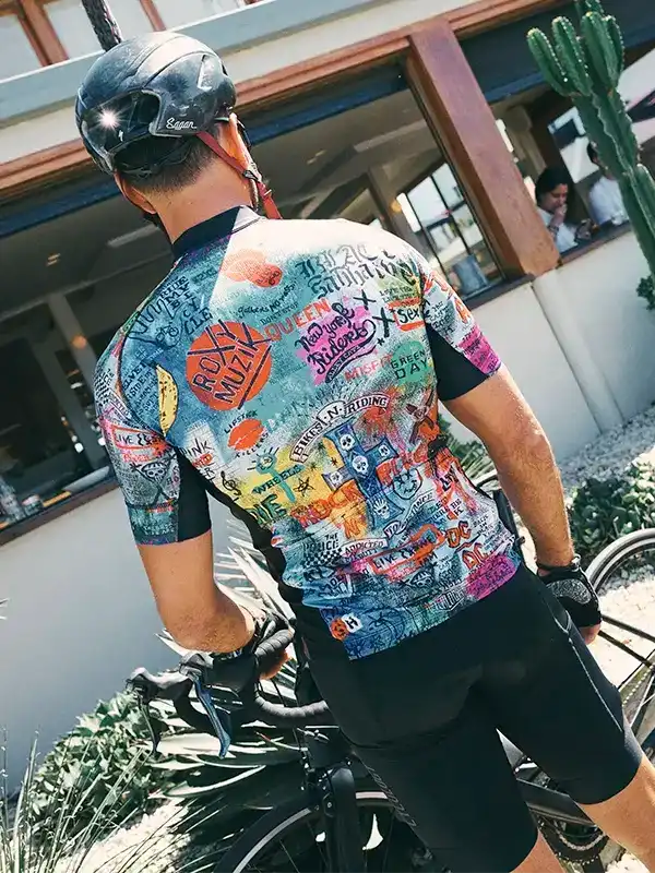 Men's colorful graphic cycling jersey with music band prints, worn with black shorts and helmet