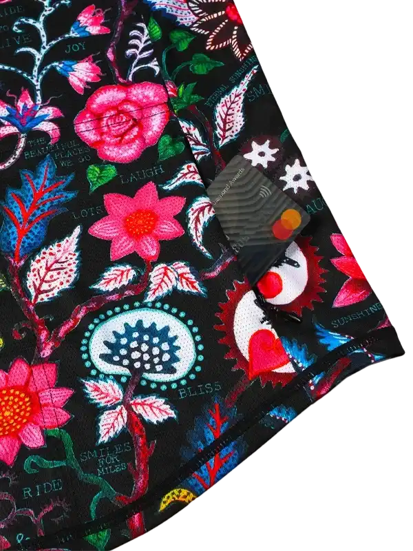 Vibrant floral cycling apparel with bold designs and motivational phrases on black fabric.