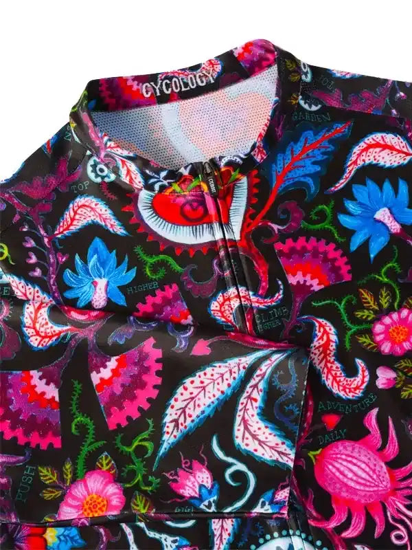 Vibrant floral cycling jersey with bold pink, blue, and green patterns on black fabric, featuring zipper and mesh collar.