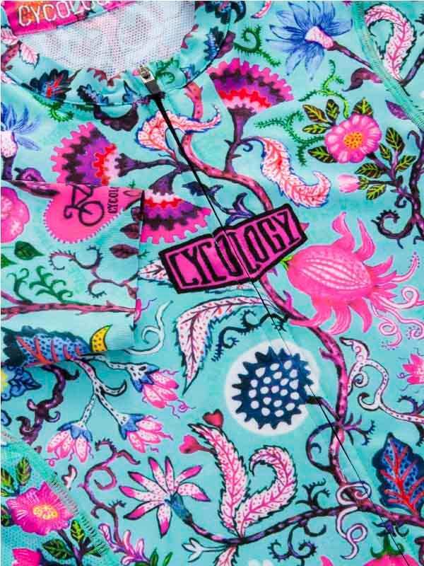 Vibrant floral cycling jersey with bold pink and blue patterns, featuring Cycology logo on chest.
