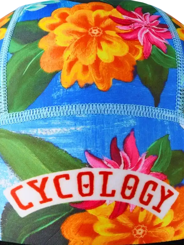 Vibrant floral cycling cap with 'CYCOLOGY' logo, featuring bold orange and pink flowers on blue background