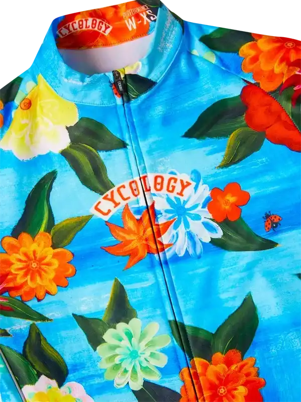Vibrant floral cycling jersey with colorful flowers and 'Cycology' logo on blue background