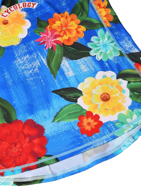 Close-up of a swimsuit with colorful floral design on a blue background, featuring the brand 'Cycology'.