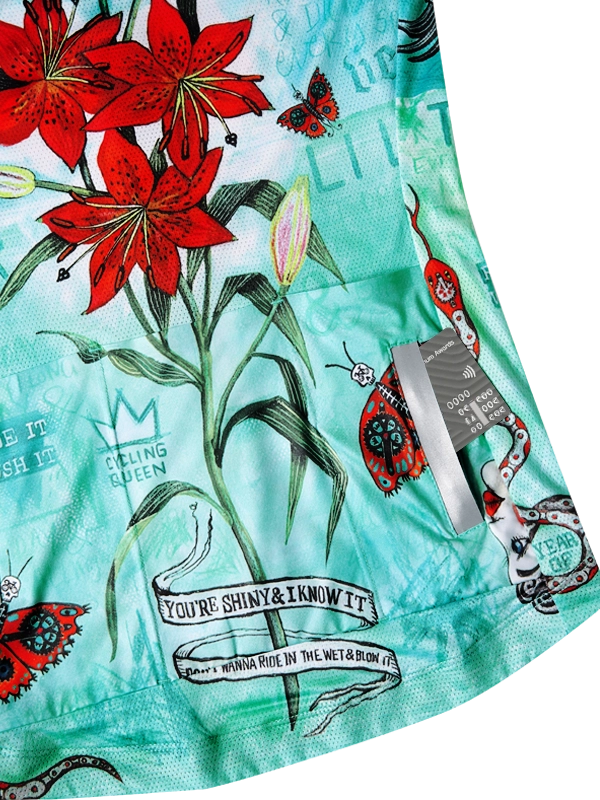 Close-up of a colorful cycling jersey  back pockets with floral and graphic designs on a light blue background.