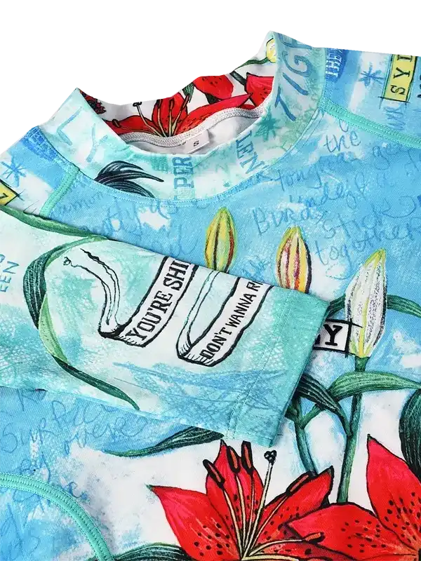 Women's cycling jersey with vibrant red lilies, teal accents, and bold graphic text on lightweight fabric