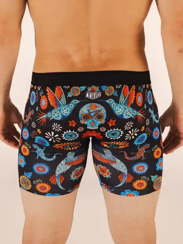 Men's cycling shorts with vibrant hummingbird and sugar skull print, featuring bold floral patterns and bike motifs.