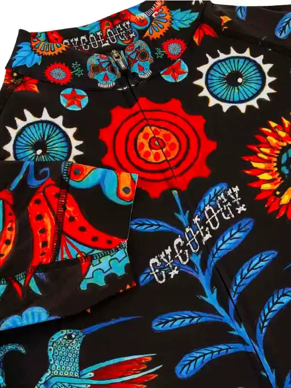 Vibrant cycling shorts with bold sugar skull, gear, and hummingbird print on black fabric