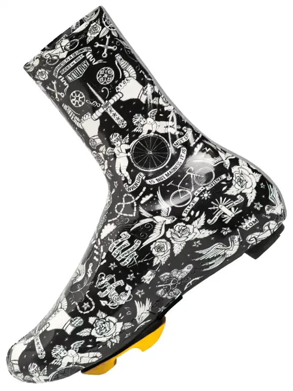Black cycling shoe cover with white tattoo-style graphics, featuring bikes, roses, and wings for road cycling protection