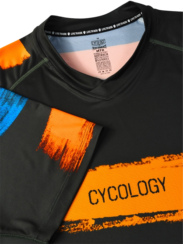 Close-up of a black and orange MTB  shirt with 'Cycology' branding.