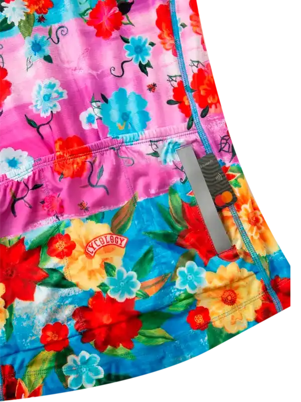 Vibrant floral cycling shorts with pink and blue panels, reflective strip, and Cycology logo patch.