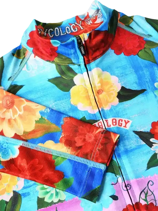 Vibrant floral cycling jersey with bold red, yellow, and blue blooms on blue background, featuring full zip and performance fabric.