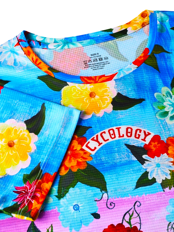 Colorful  pink and blue floral-patterned tech t shirt with a visible Cycology  brand logo 
