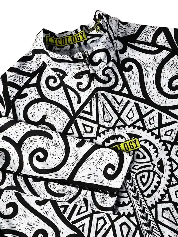 Black and white patterned cycling jersey with bold swirls and geometric designs, featuring yellow brand tag