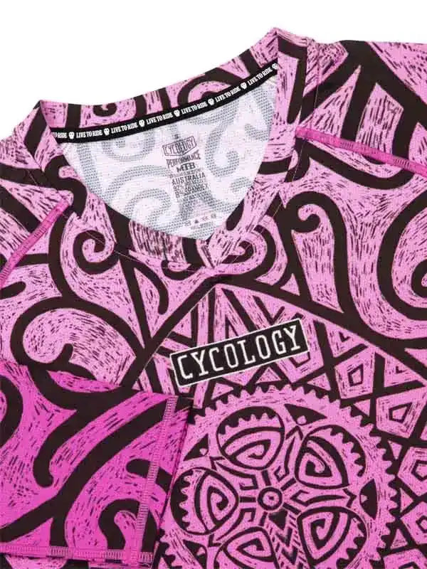 Pink and black patterned cycling jersey with 'CYCOLOGY' logo, featuring bold tribal designs and performance fabric details.