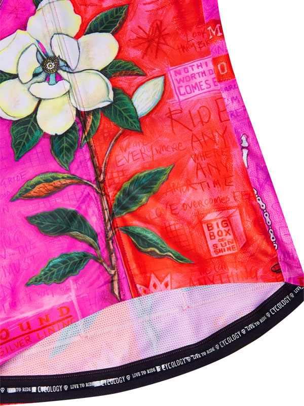 Close-up of a bicycle wheel with floral design and text on a pink background