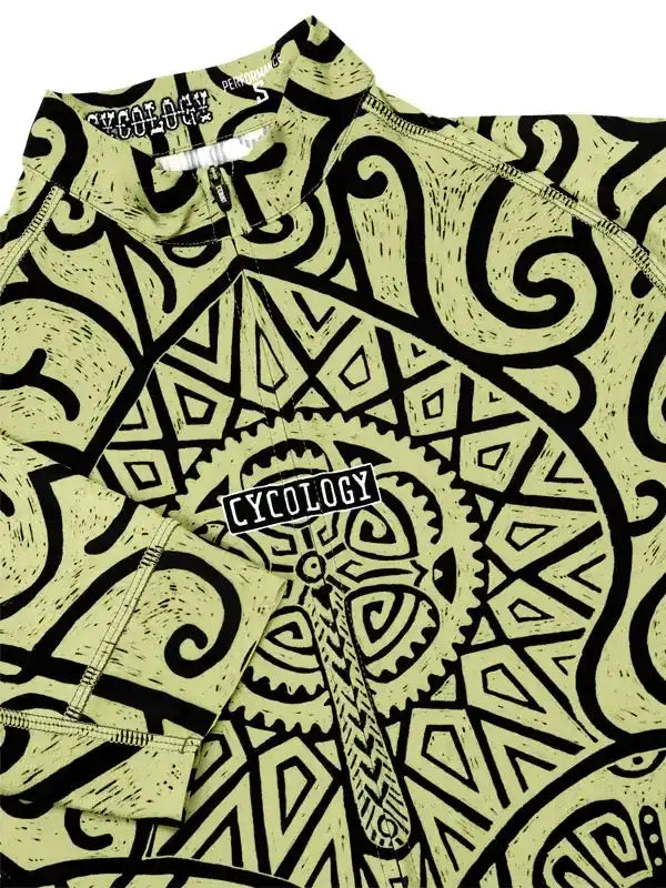 Men's cycling jersey with bold black geometric and tribal print on light green fabric, featuring zipper and brand tag