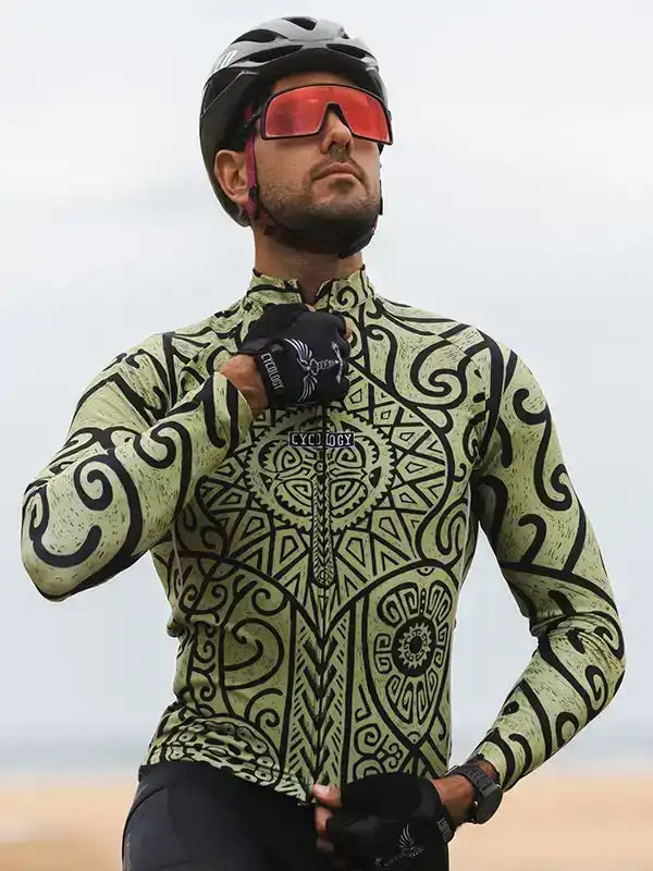 Man wearing patterned long sleeve cycling jersey, helmet, and red-tinted sunglasses outdoors