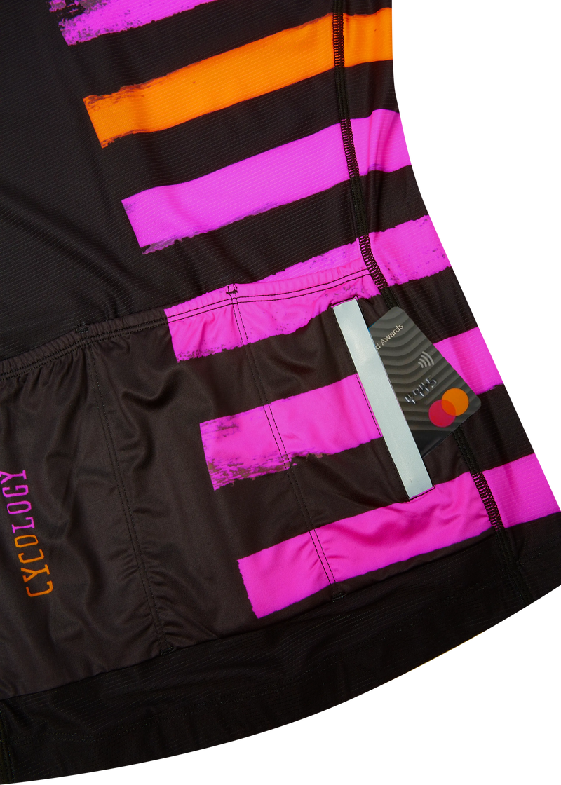 Close-up of a black, pink, and orange striped cycling jersey with 'Cycology' branding.