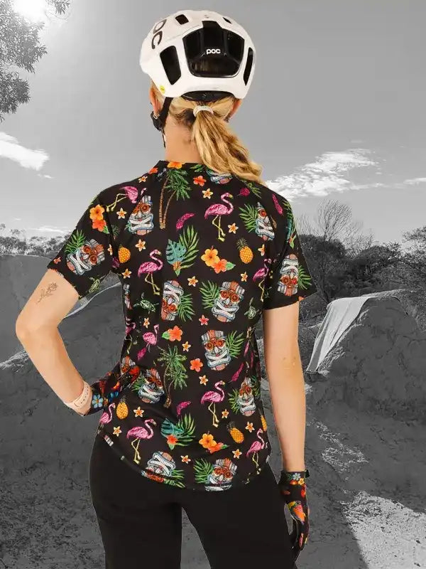 Woman wearing tropical flamingo print cycling jersey with POC helmet, ideal for mountain biking adventures.
