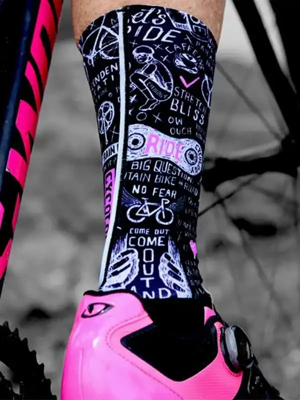 Black cycling socks with bold pink and white bike-themed graphics, paired with pink cycling shoes.