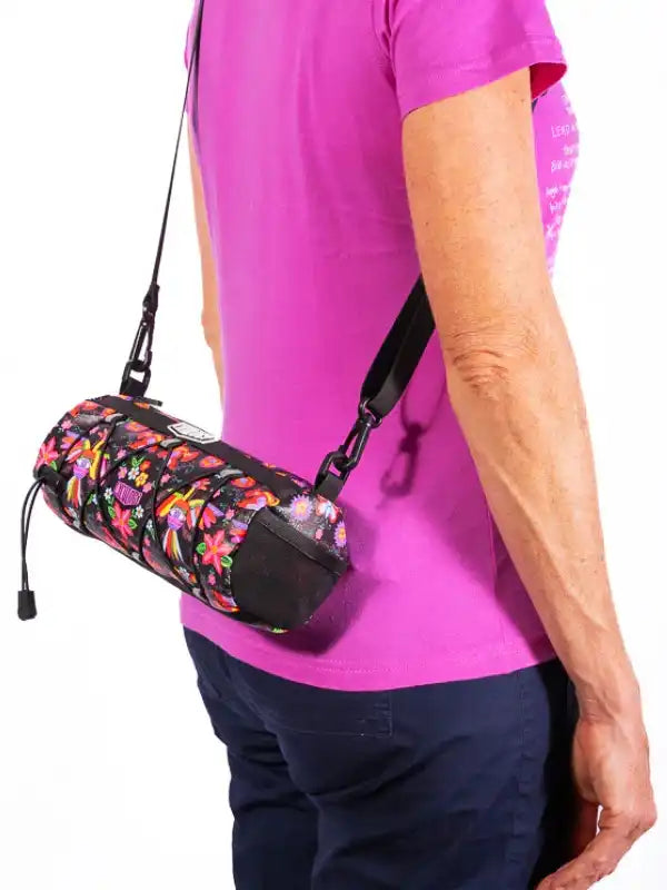 Colorful floral cycling waist bag with adjustable strap, worn over pink shirt for bike rides.