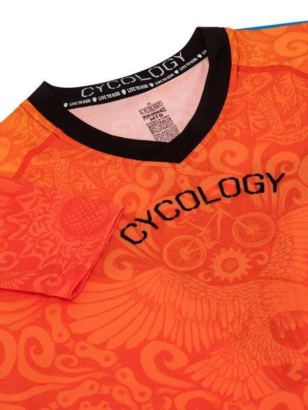 Vibrant orange cycling jersey with bold Cycology logo and intricate gear-wing pattern, ideal for men's and women's rides.
