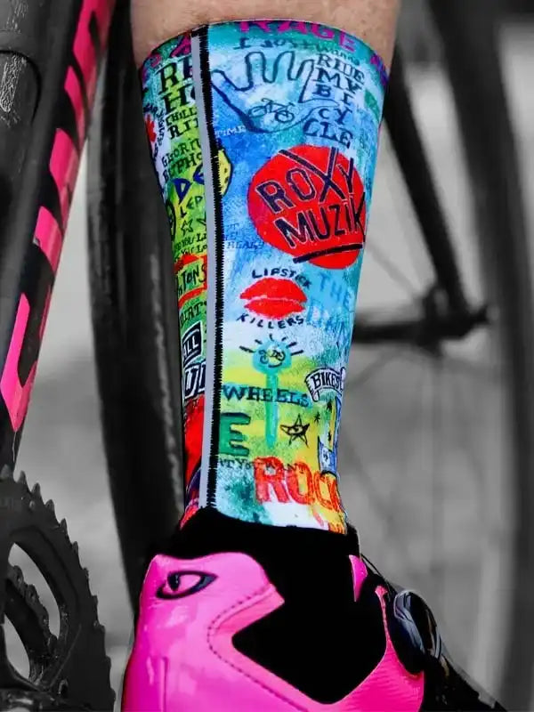 Colorful cycling socks with graffiti-style graphics, worn with pink cycling shoes and bike frame